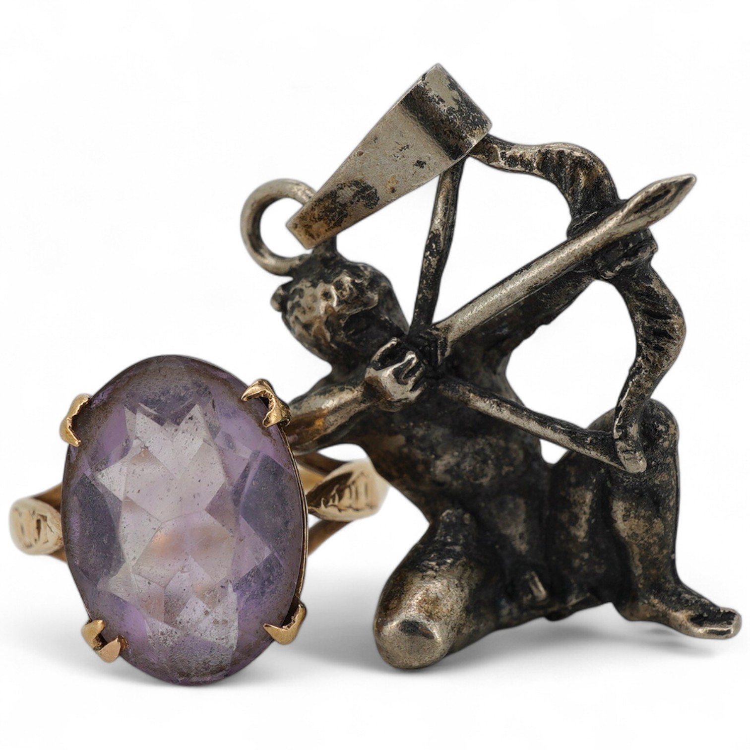 An amethyst ring and a pendant, the ring set with an oval amethyst, mounted in 9ct gold, size N, British hallmarks; the pendant modelled as an archer, length 3.6cm